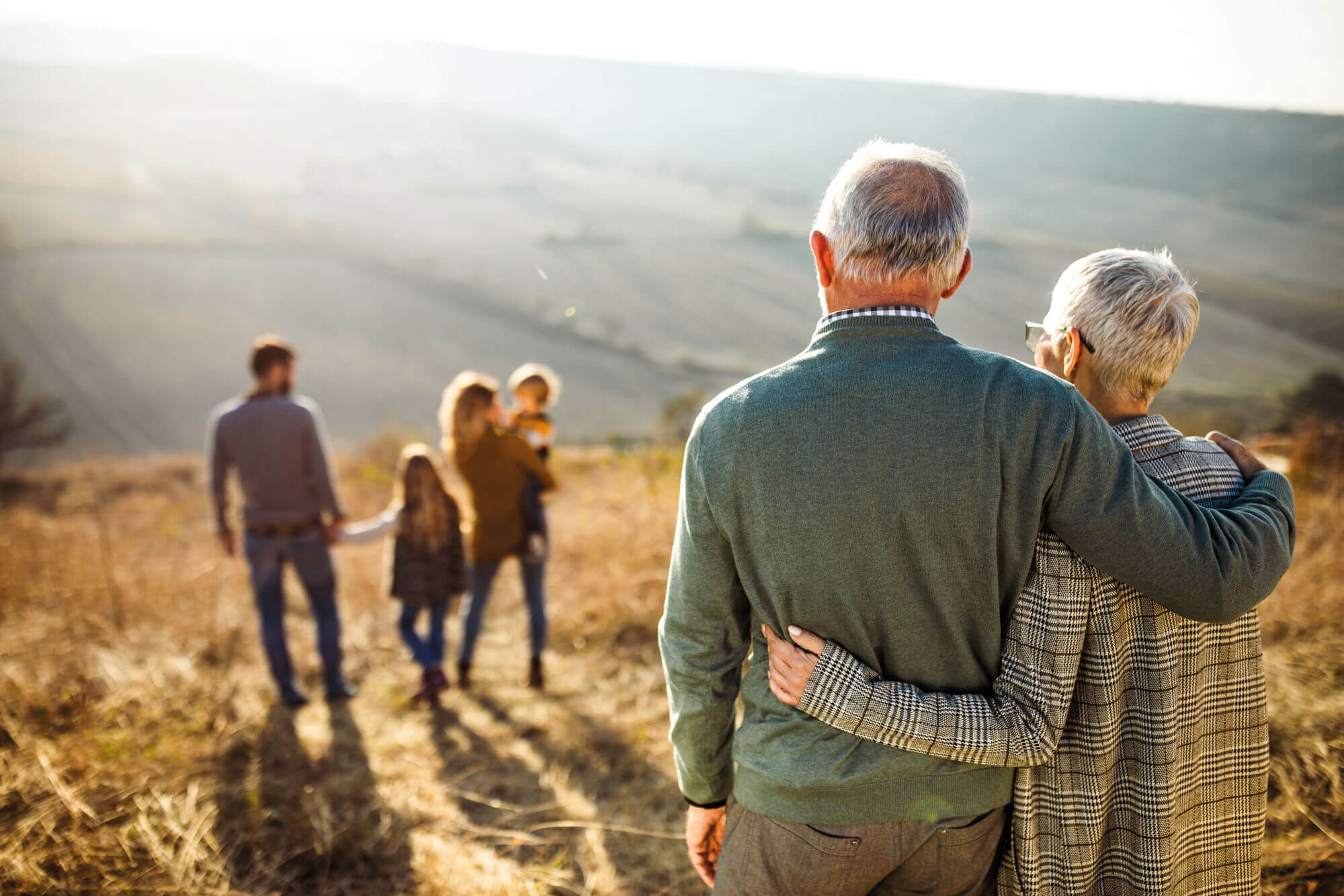 Elderly man and lady watching their younger family